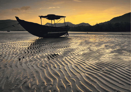 Ein Fischerboot im Sonnenuntergang spiegelt die Ruhe der Dão-Region wider. Ideal für elegante und mineralische Weine aus Höhenlagen.